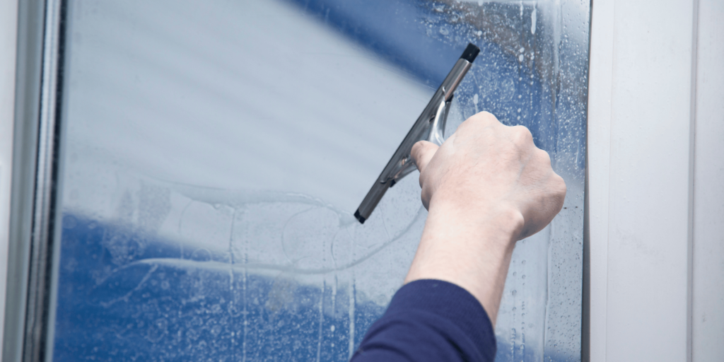 Window film being applied with a squeegie.