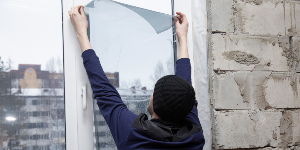 Man applying window film to a glass door.